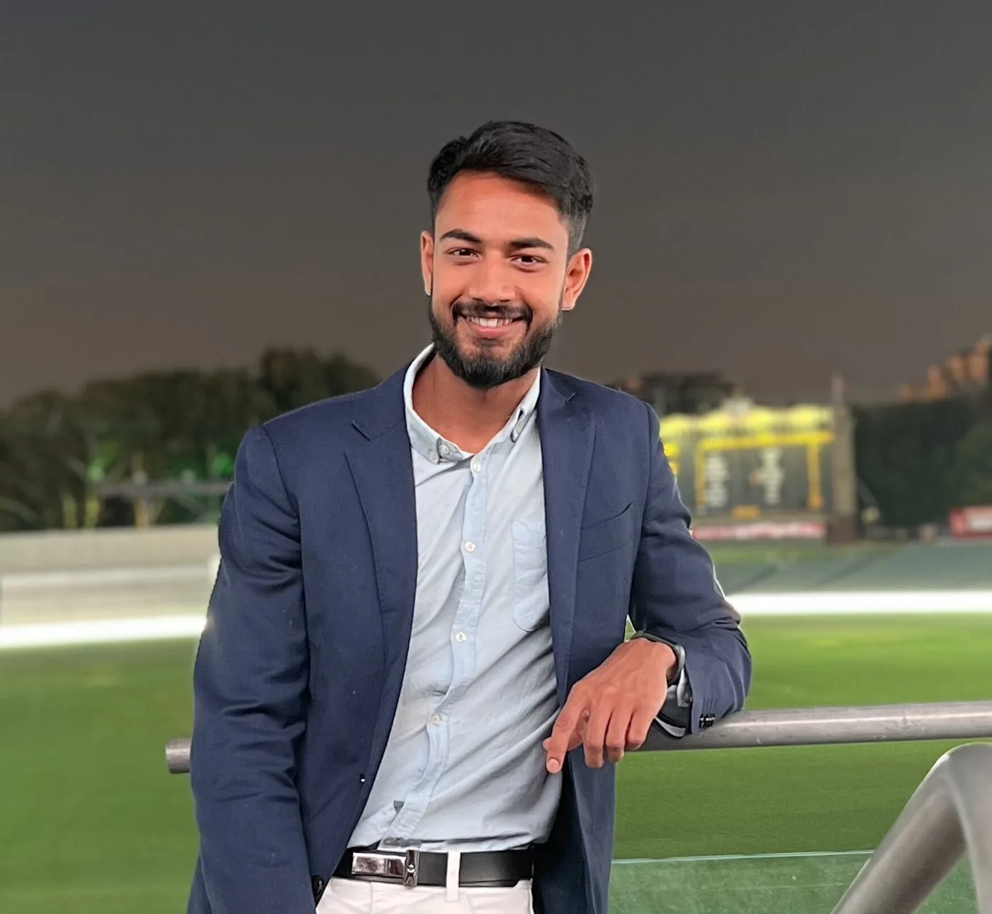 Devarshi Desai, founder and host of Internash, smiling at a cricket ground at night